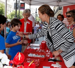 Doña Elena coloca la insignia de Cáritas a un niño que habían hecho un donativo